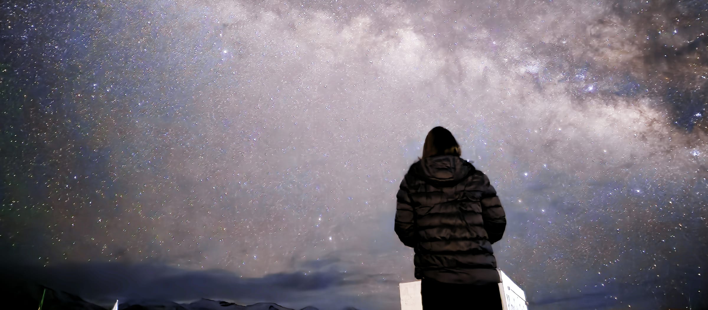 A figure standing under the Milky Way at Hanle