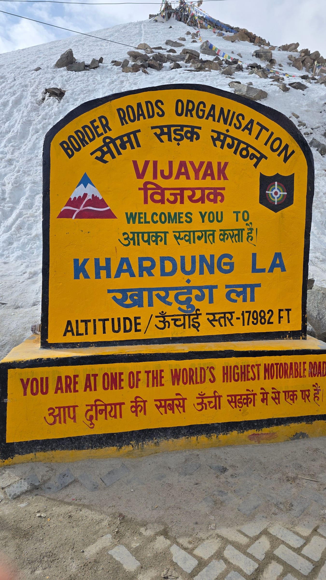 The Khardung La summit sign reading altitude 17,982 ft