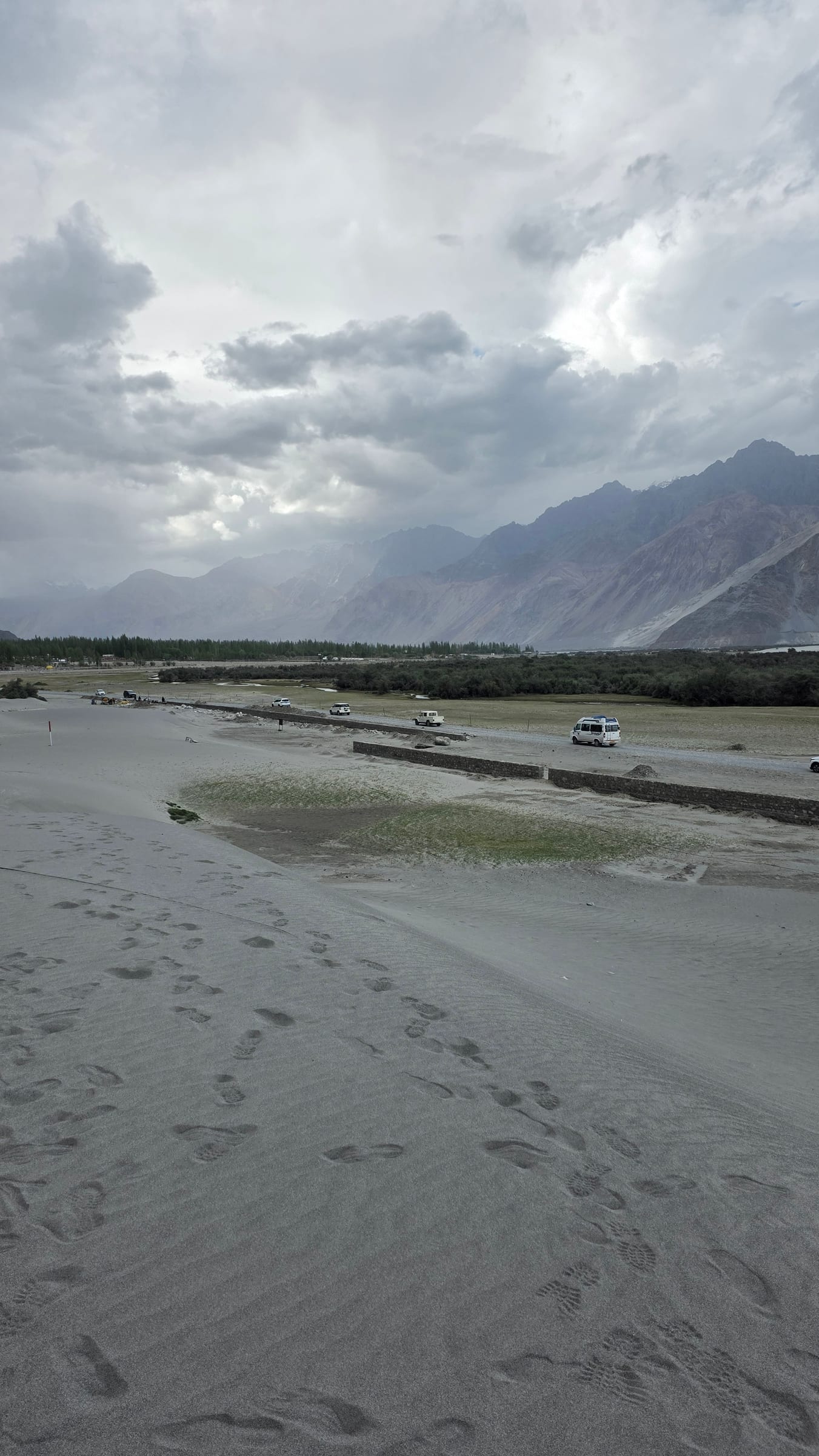 Sand dunes and the road below the mountains near Hunder
