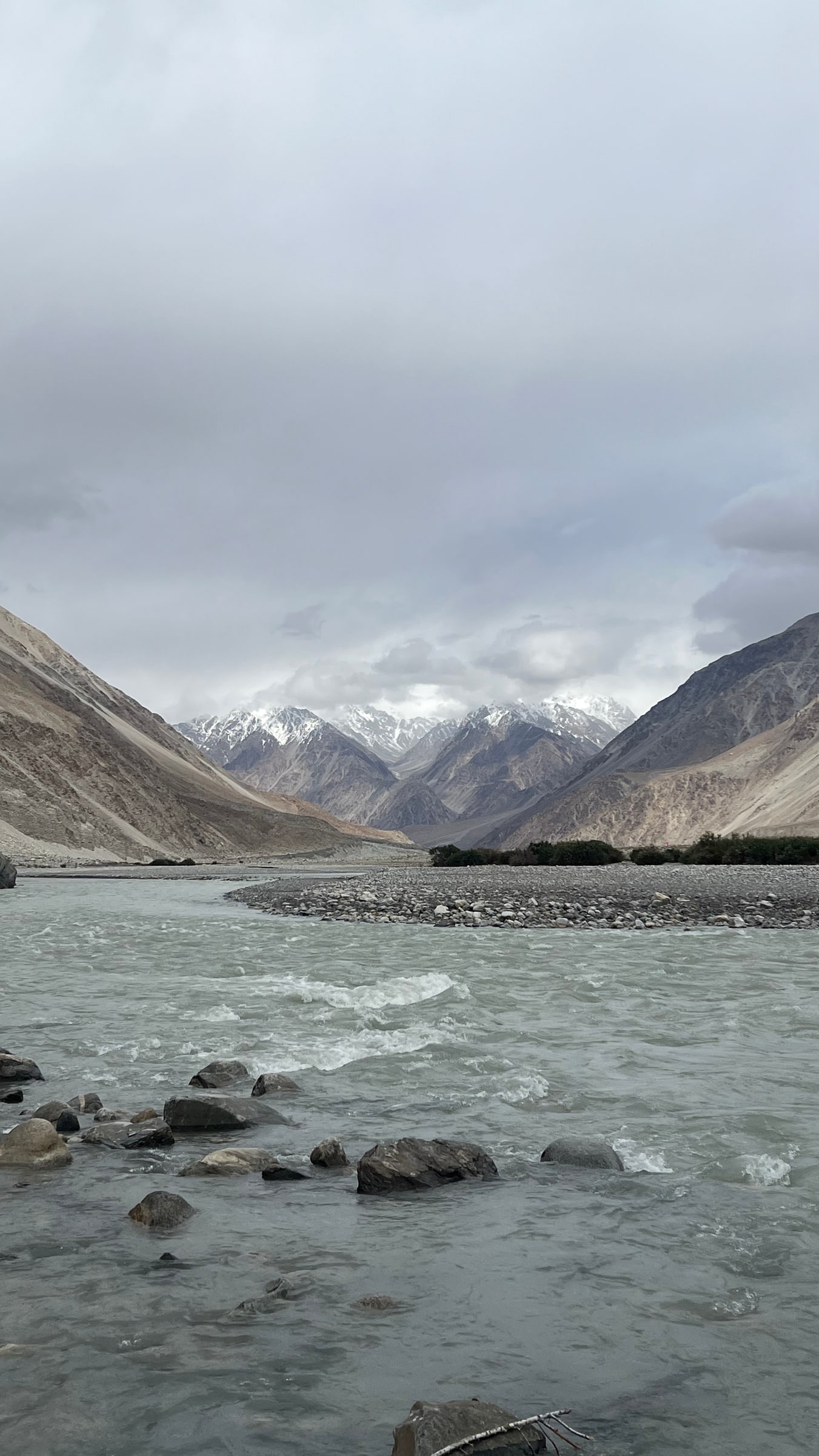 A wide river through the Nubra valley toward snow peaks