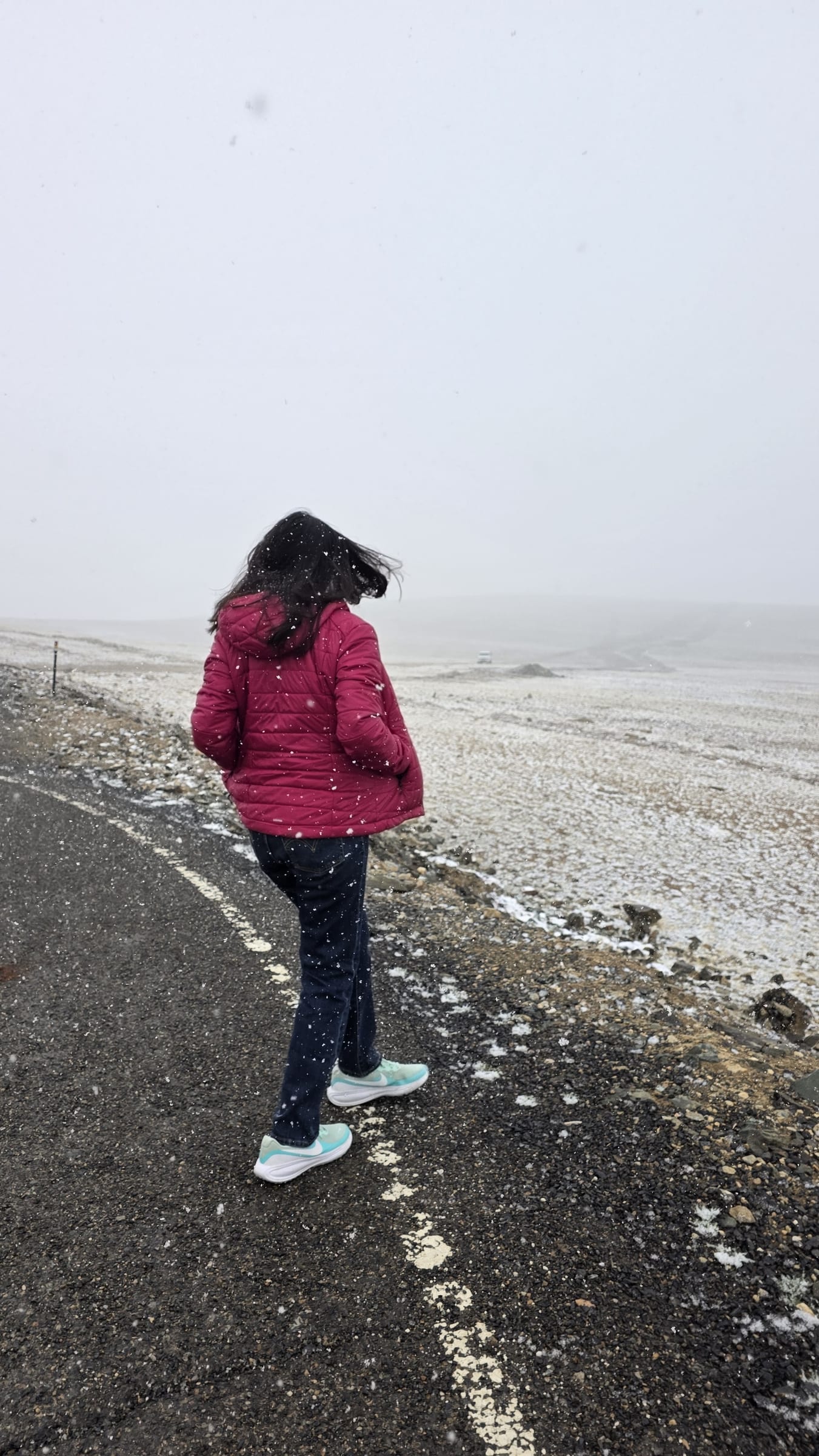 Walking along the road at Umling La in falling snow