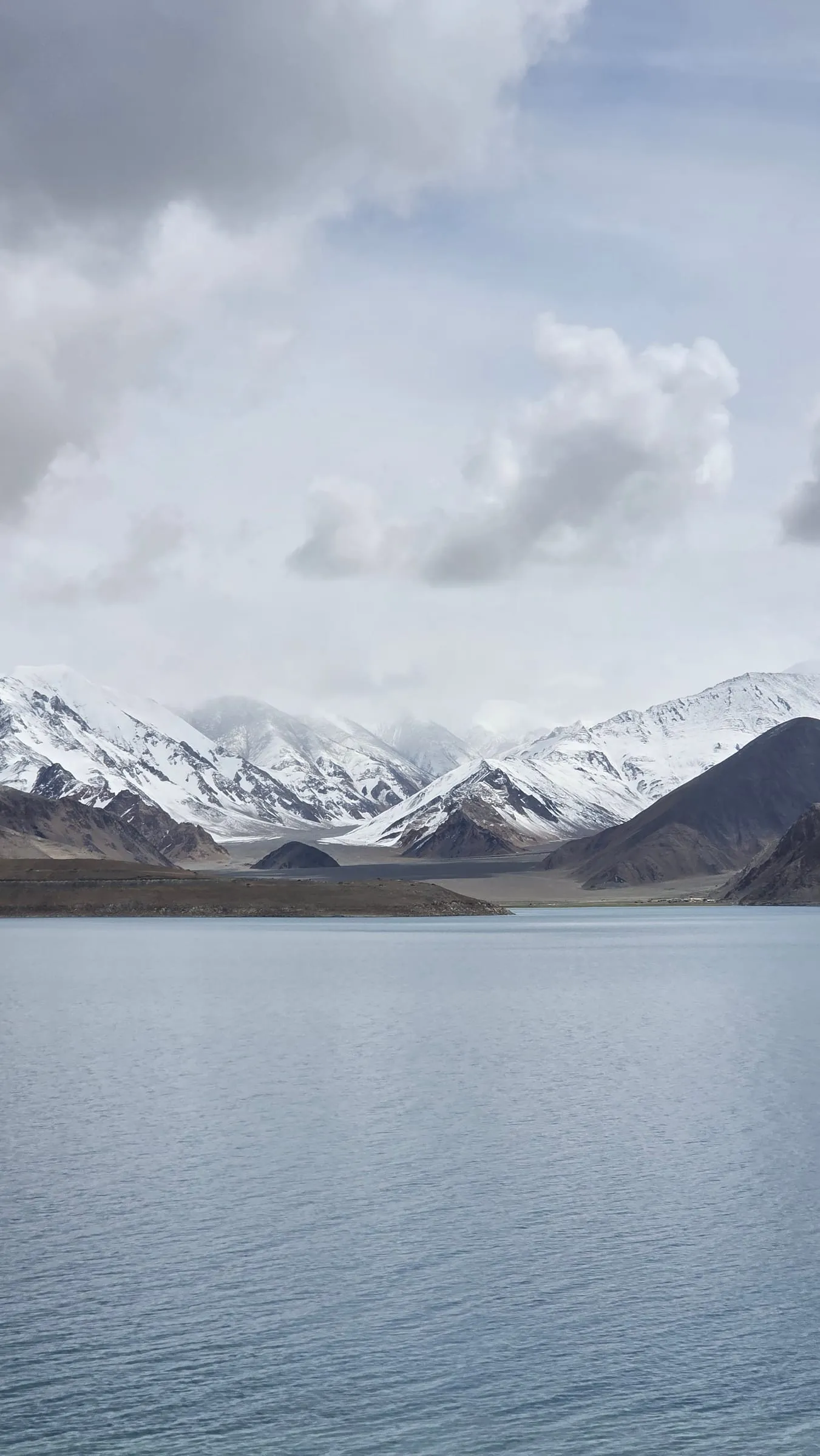 A still high-altitude lake beneath snow peaks in Ladakh